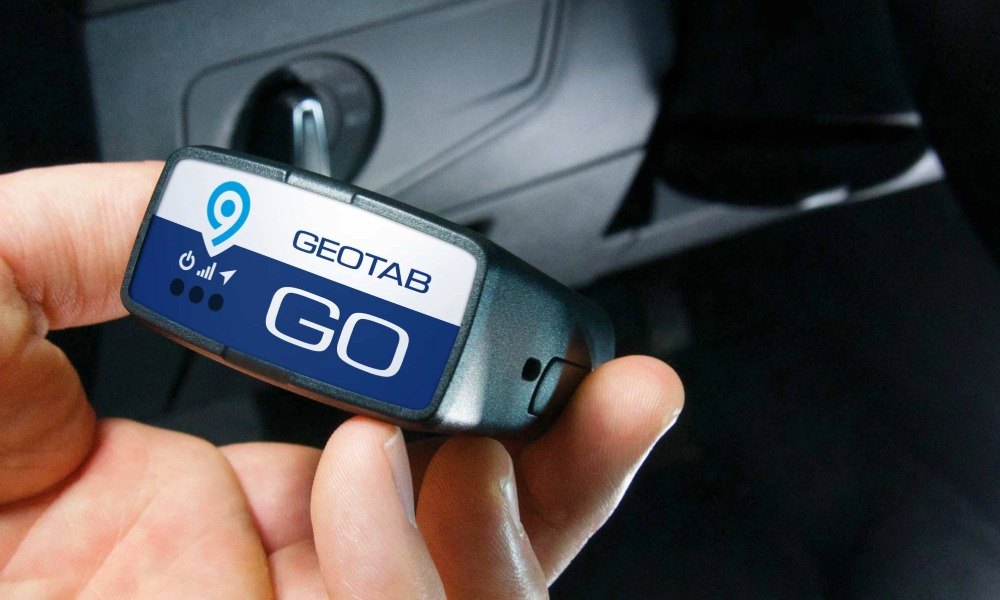 A Geotab GO9 being plugged into the OBD-II port